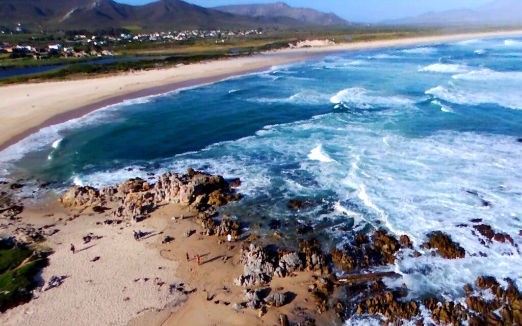 Strand und Felsküste bei Hermanus mit Brandung, aus der Luft