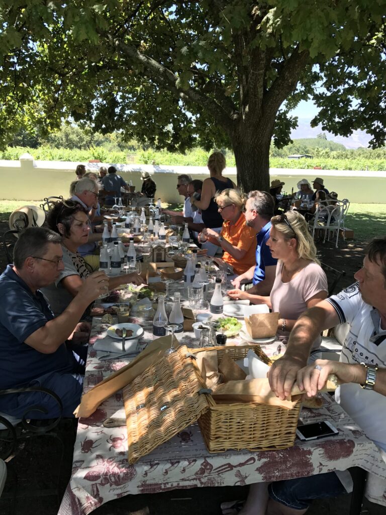 Mittagessen der Reisegruppe an einer langen Tafel im Freien